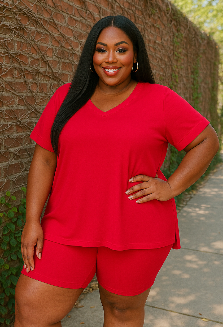 Woman wearing a red outfit standing against a textured wall.
